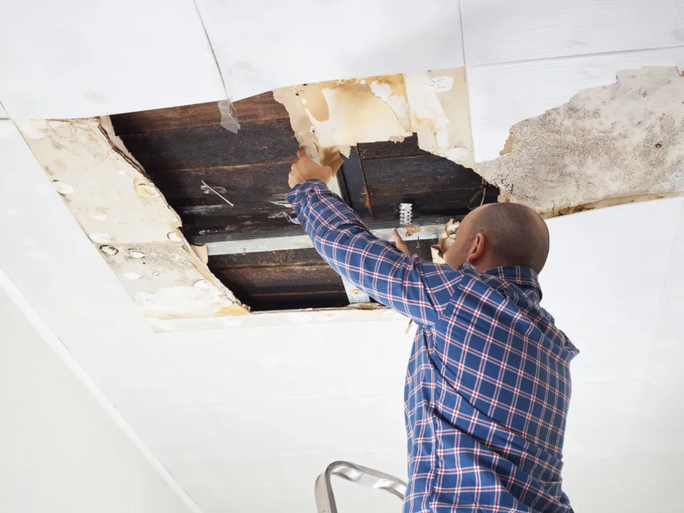 Man repairing collapsed ceiling.